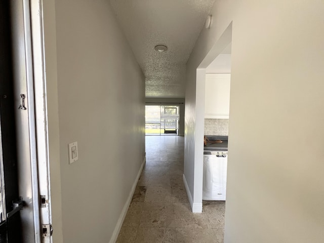 717 Gardens Dr Unit 106, Pompano Beach, FL 33069 - corridor with a textured ceiling and baseboards