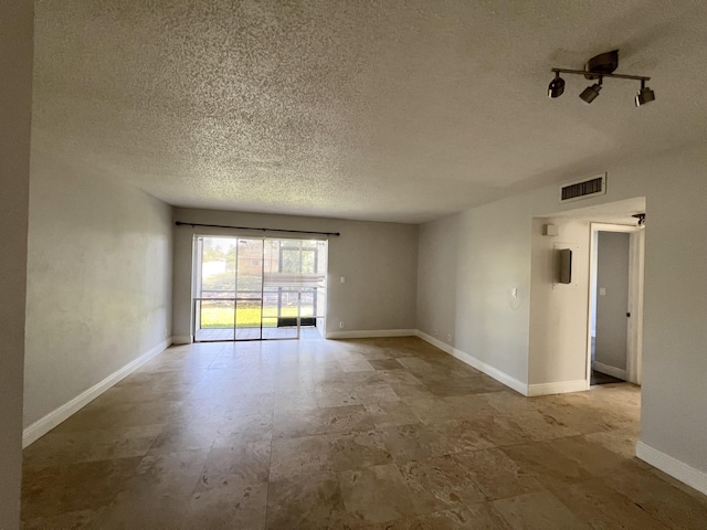 717 Gardens Dr Unit 106, Pompano Beach, FL 33069 - empty room featuring a textured ceiling and baseboards