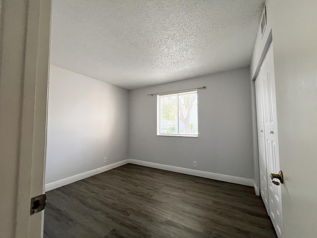 717 Gardens Dr Unit 106, Pompano Beach, FL 33069 - unfurnished room with a textured ceiling and dark wood finished floors