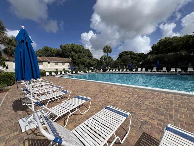 717 Gardens Dr Unit 106, Pompano Beach, FL 33069 - community pool featuring a patio area and view of wooded area