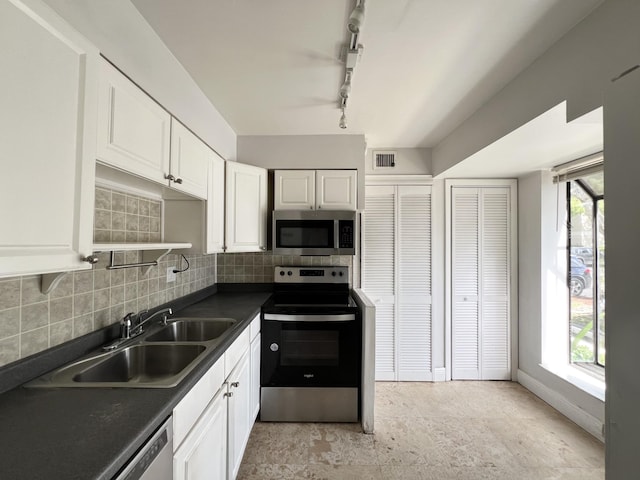 717 Gardens Dr Unit 106, Pompano Beach, FL 33069 - kitchen featuring stainless steel appliances, dark countertops, tasteful backsplash, and white cabinetry