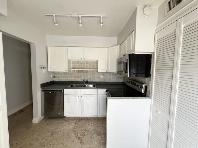717 Gardens Dr Unit 106, Pompano Beach, FL 33069 - kitchen featuring stainless steel appliances, dark countertops, white cabinets, track lighting, and decorative backsplash