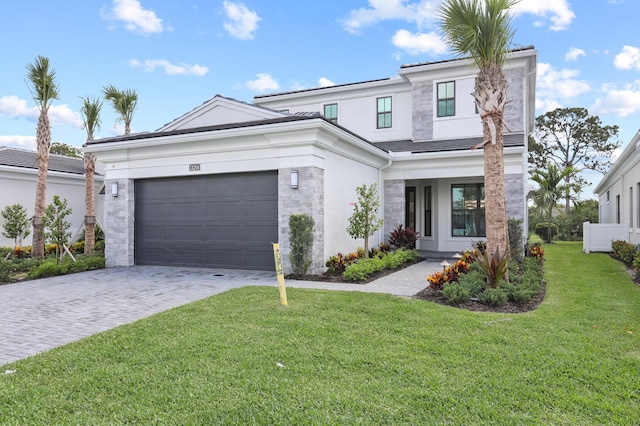 13214 Artisan Cir, Palm Beach Gardens, FL 33418 - view of front facade featuring stone siding, decorative driveway, a garage, a front lawn, and stucco siding
