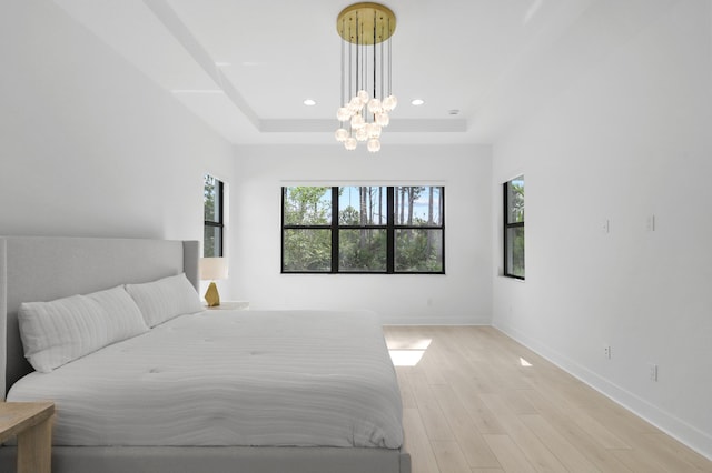 13214 Artisan Cir, Palm Beach Gardens, FL 33418 - bedroom with a chandelier, a tray ceiling, light wood-type flooring, and recessed lighting