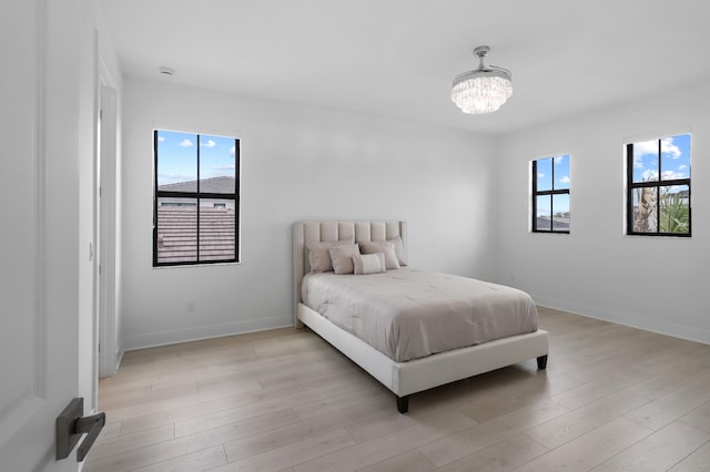 13214 Artisan Cir, Palm Beach Gardens, FL 33418 - bedroom featuring a chandelier and light wood-style floors
