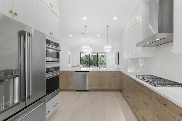 13214 Artisan Cir, Palm Beach Gardens, FL 33418 - kitchen with appliances with stainless steel finishes, wall chimney range hood, recessed lighting, light wood-style floors, and a peninsula