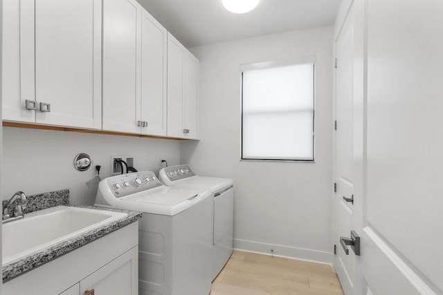 13214 Artisan Cir, Palm Beach Gardens, FL 33418 - laundry room with washing machine and dryer, light wood-style floors, and cabinet space
