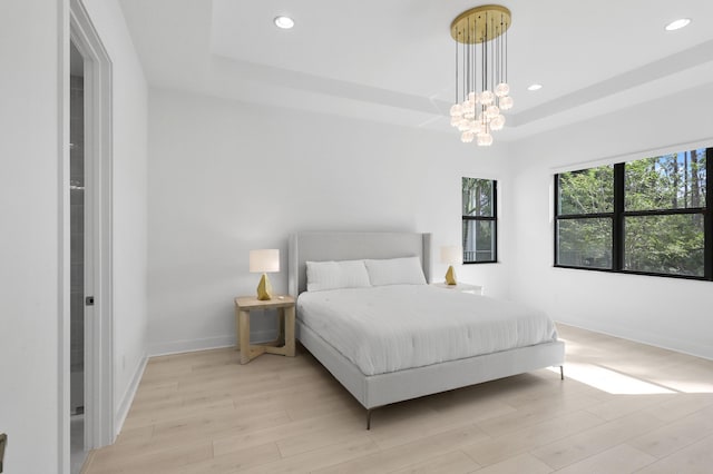 13214 Artisan Cir, Palm Beach Gardens, FL 33418 - bedroom with a raised ceiling, light wood-style flooring, recessed lighting, and a chandelier