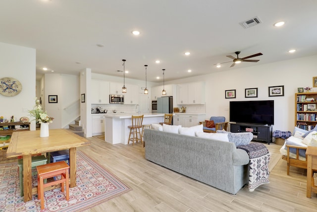 1416 Gopher Ter, Stuart, FL 34994 - living room featuring stairway, light wood-style floors, a ceiling fan, and recessed lighting