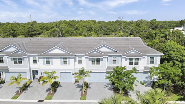 1416 Gopher Ter, Stuart, FL 34994 - view of front facade featuring a garage, driveway, and a forest view