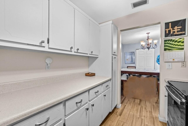 7376 W Oakridge Cir Unit C4320, Lake Worth, FL 33462 - kitchen featuring electric stove, light wood-type flooring, white cabinetry, a chandelier, and light countertops