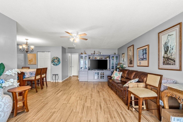 7376 W Oakridge Cir Unit C4320, Lake Worth, FL 33462 - living room featuring ceiling fan, light wood-style floors, a chandelier, and a textured ceiling