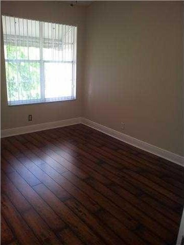 5051 Pointe Emerald Ln Unit 5051, Boca Raton, FL 33486 - spare room with baseboards and dark wood-style floors