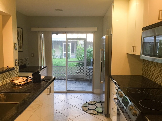 5051 Pointe Emerald Ln Unit 5051, Boca Raton, FL 33486 - kitchen with appliances with stainless steel finishes, tasteful backsplash, white cabinetry, and dark stone countertops