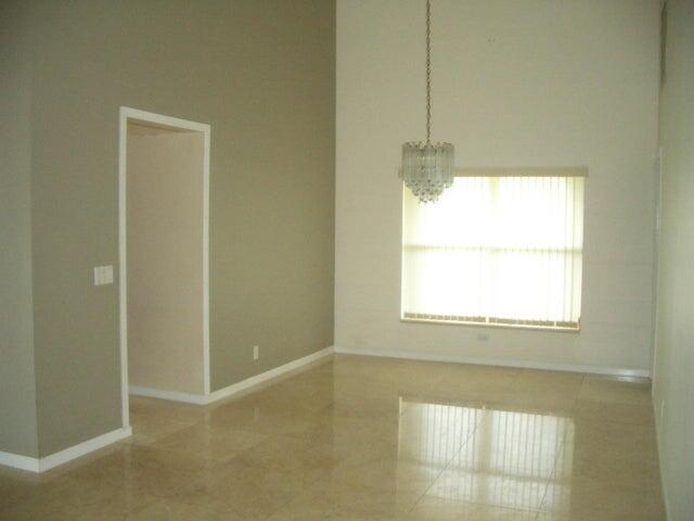 24 Dunbar Rd, Palm Beach Gardens, FL 33418 - unfurnished dining area with a chandelier and baseboards