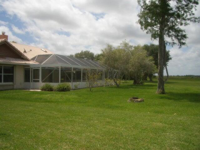 24 Dunbar Rd, Palm Beach Gardens, FL 33418 - view of green lawn with a lanai