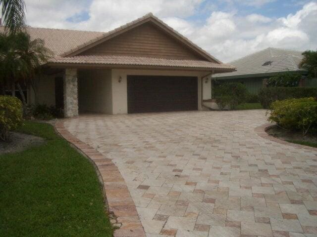 24 Dunbar Rd, Palm Beach Gardens, FL 33418 - ranch-style house featuring an attached garage, a tile roof, decorative driveway, and stucco siding