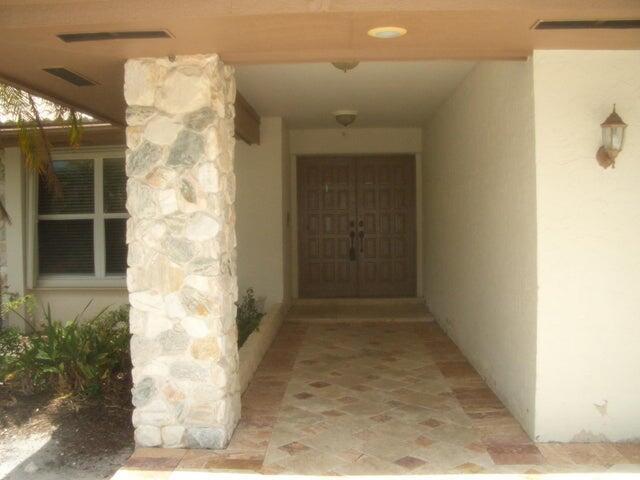 24 Dunbar Rd, Palm Beach Gardens, FL 33418 - doorway to property with stucco siding