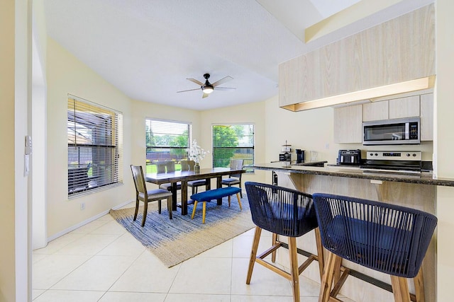 2282 NE Marlberry Ln, Jensen Beach, FL 34957 - kitchen featuring stainless steel appliances, a ceiling fan, a breakfast bar area, and light tile patterned flooring