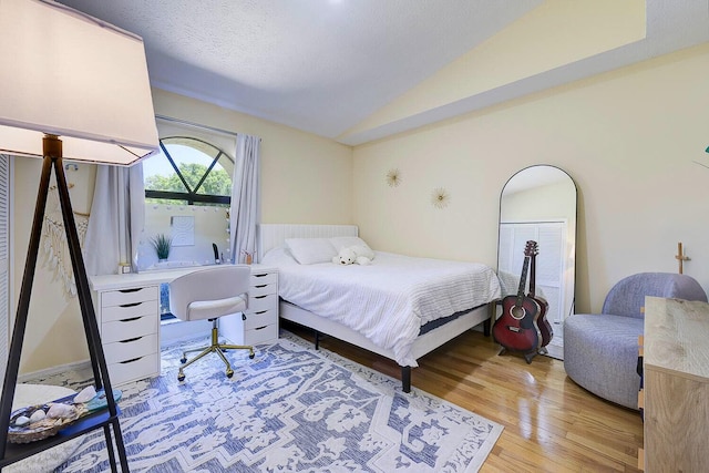2282 NE Marlberry Ln, Jensen Beach, FL 34957 - bedroom with vaulted ceiling, light wood-style flooring, and an office area