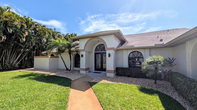 2282 NE Marlberry Ln, Jensen Beach, FL 34957 - view of front of house featuring french doors, a front lawn, and stucco siding