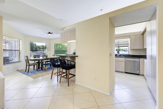 2282 NE Marlberry Ln, Jensen Beach, FL 34957 - kitchen featuring stainless steel dishwasher, dark countertops, light tile patterned floors, and ceiling fan