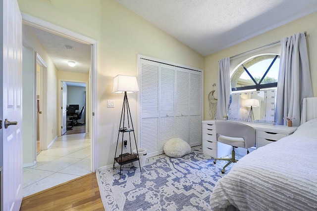 2282 NE Marlberry Ln, Jensen Beach, FL 34957 - bedroom featuring vaulted ceiling, a desk, light wood-type flooring, a textured ceiling, and a closet
