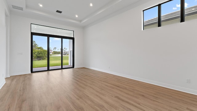 203 SE Via Sangro, Port Saint Lucie, FL 34952 - empty room featuring a tray ceiling, light wood-style flooring, and recessed lighting
