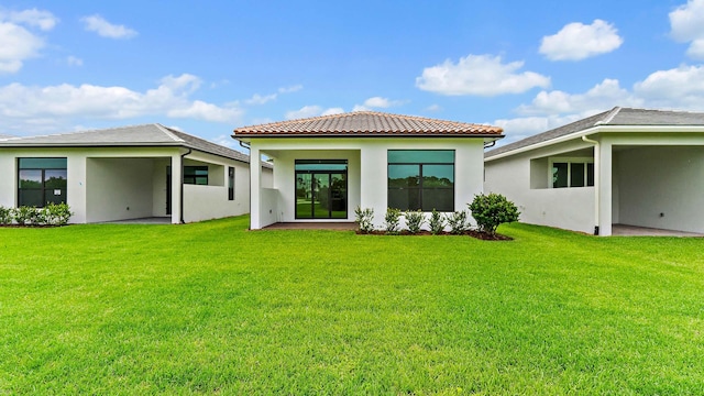 203 SE Via Sangro, Port Saint Lucie, FL 34952 - rear view of property featuring a yard, stucco siding, and a tile roof