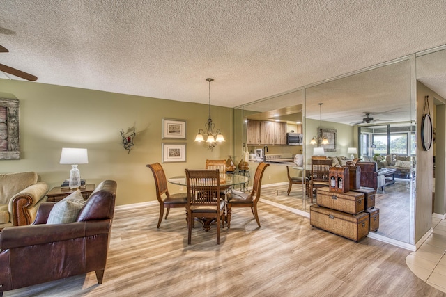11186 Green Lake Dr Unit 202, Boynton Beach, FL 33437 - dining room with ceiling fan, light wood-style floors, a textured ceiling, and a chandelier