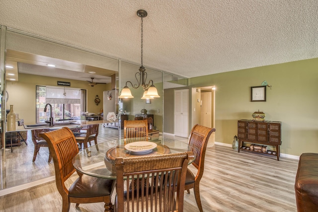 11186 Green Lake Dr Unit 202, Boynton Beach, FL 33437 - dining room featuring a textured ceiling, light wood-style flooring, and a chandelier
