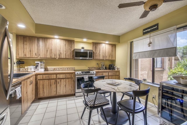 11186 Green Lake Dr Unit 202, Boynton Beach, FL 33437 - kitchen featuring stainless steel appliances, beverage cooler, brown cabinets, a ceiling fan, and light countertops