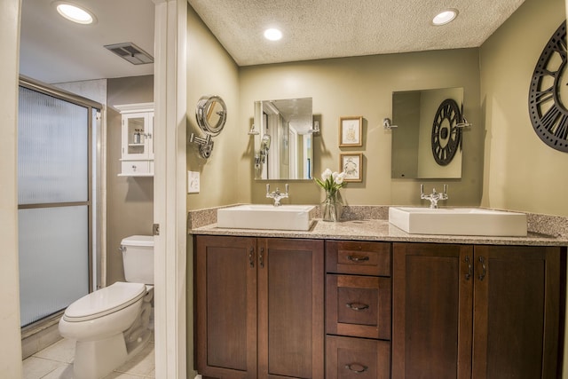 11186 Green Lake Dr Unit 202, Boynton Beach, FL 33437 - bathroom featuring a shower stall, double vanity, tile patterned floors, recessed lighting, and a textured ceiling