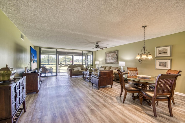 11186 Green Lake Dr Unit 202, Boynton Beach, FL 33437 - dining space with a textured ceiling, light wood-style floors, ceiling fan, and a chandelier