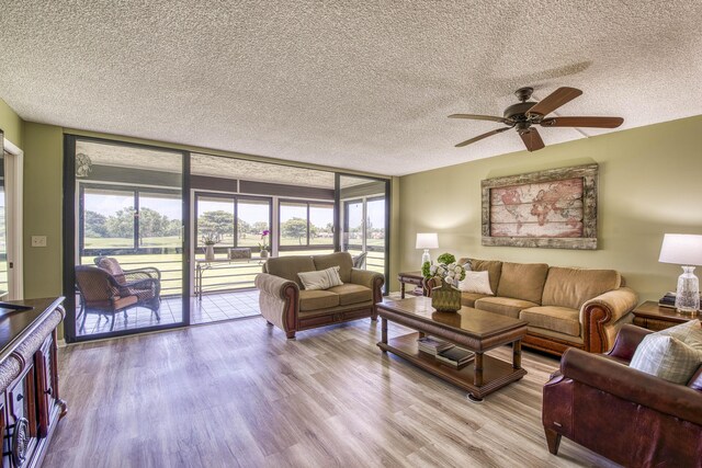 11186 Green Lake Dr Unit 202, Boynton Beach, FL 33437 - living area with a textured ceiling, a ceiling fan, wood finished floors, and a wall of windows