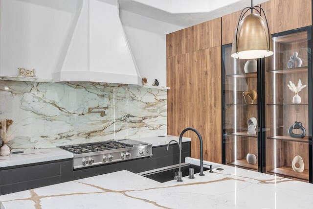 11533 Manatee Ter Unit 11533, Lake Worth, FL 33449 - kitchen with premium range hood, stainless steel gas cooktop, light stone countertops, and tasteful backsplash