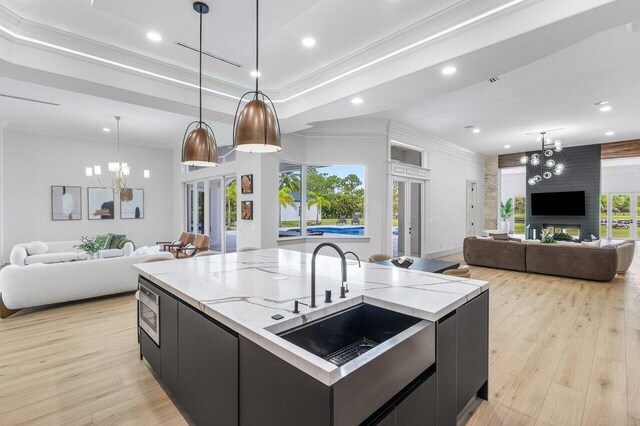 11533 Manatee Ter Unit 11533, Lake Worth, FL 33449 - kitchen with a chandelier, open floor plan, dark cabinetry, crown molding, and a center island with sink
