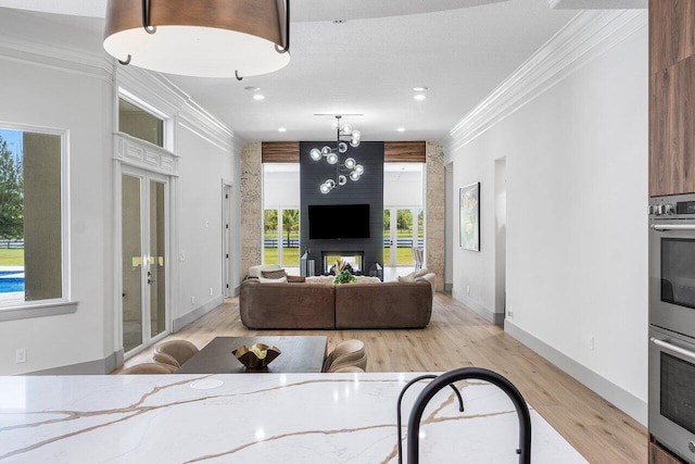11533 Manatee Ter Unit 11533, Lake Worth, FL 33449 - living room featuring crown molding, light wood-style flooring, a chandelier, recessed lighting, and a multi sided fireplace