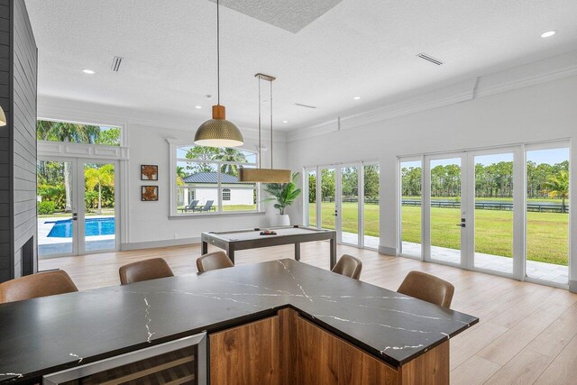 11533 Manatee Ter Unit 11533, Lake Worth, FL 33449 - kitchen with french doors, open floor plan, crown molding, light wood finished floors, and a textured ceiling