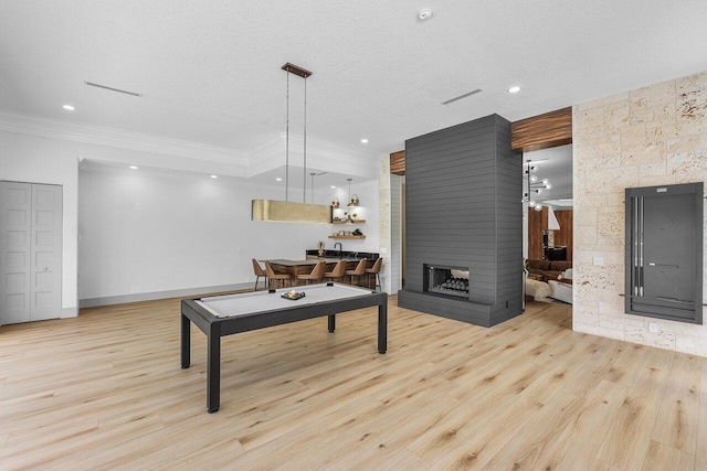 11533 Manatee Ter Unit 11533, Lake Worth, FL 33449 - game room featuring ornamental molding, a multi sided fireplace, wood finished floors, recessed lighting, and a textured ceiling