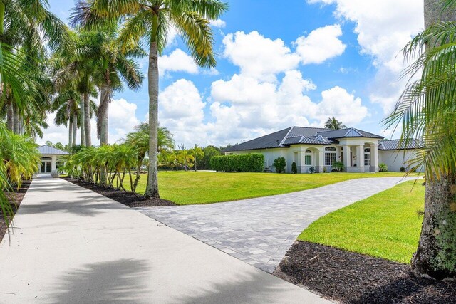 11533 Manatee Ter Unit 11533, Lake Worth, FL 33449 - view of front of house featuring a front lawn, stucco siding, and a metal roof