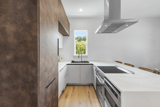 11533 Manatee Ter Unit 11533, Lake Worth, FL 33449 - kitchen with island range hood, modern cabinets, stainless steel range, a peninsula, and recessed lighting