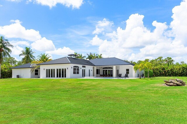 11533 Manatee Ter Unit 11533, Lake Worth, FL 33449 - back of property with a ceiling fan, a patio area, a lawn, and a metal roof