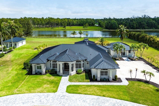 11533 Manatee Ter Unit 11533, Lake Worth, FL 33449 - back of house featuring a water view, stucco siding, a metal roof, and a lawn