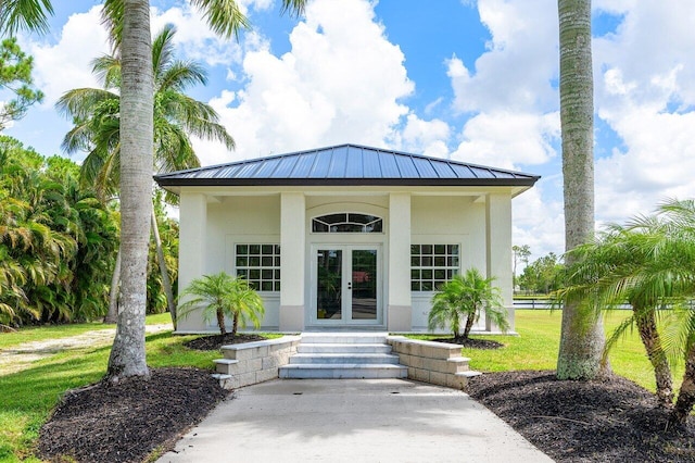 11533 Manatee Ter Unit 11533, Lake Worth, FL 33449 - entrance to property with french doors, stucco siding, a yard, and a metal roof