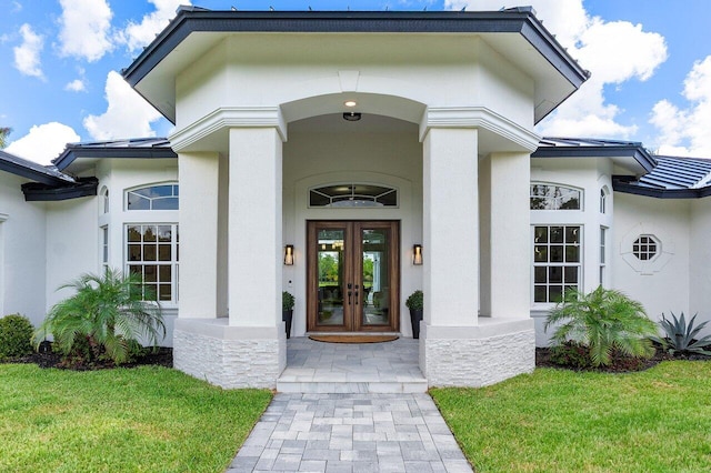 11533 Manatee Ter Unit 11533, Lake Worth, FL 33449 - view of exterior entry with french doors, stucco siding, a standing seam roof, and a yard