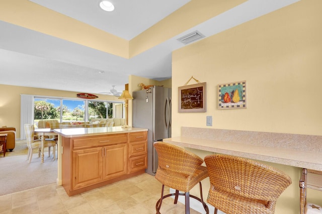 18429 SE Wood Haven Ln Unit G, Jupiter, FL 33469 - kitchen with freestanding refrigerator, a peninsula, light countertops, open floor plan, and light flooring