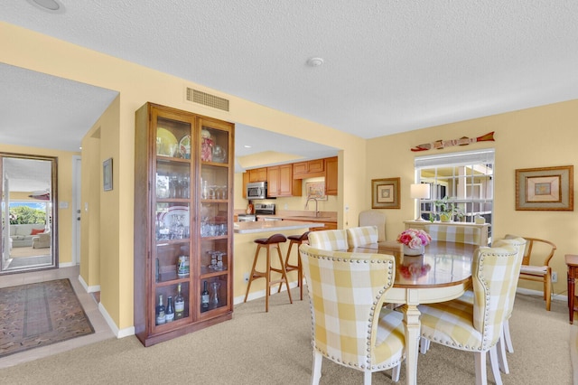 18429 SE Wood Haven Ln Unit G, Jupiter, FL 33469 - dining space with a textured ceiling and light colored carpet
