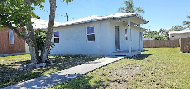 716 NW 16th St, Belle Glade, FL 33430 - view of home's exterior with stucco siding and a metal roof