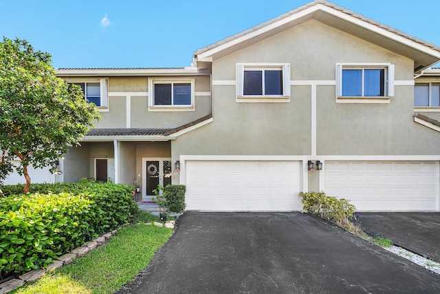 5404 E Pointe Villa Dr Unit 5406, Lighthouse Point, FL 33064 - view of front of house featuring driveway, stucco siding, an attached garage, and a tile roof